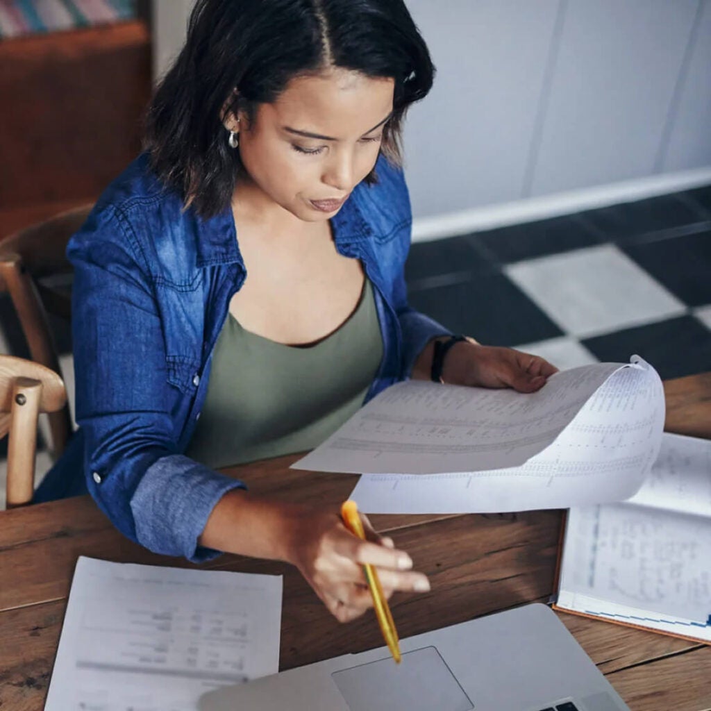 Woman writing on papers at a desk.