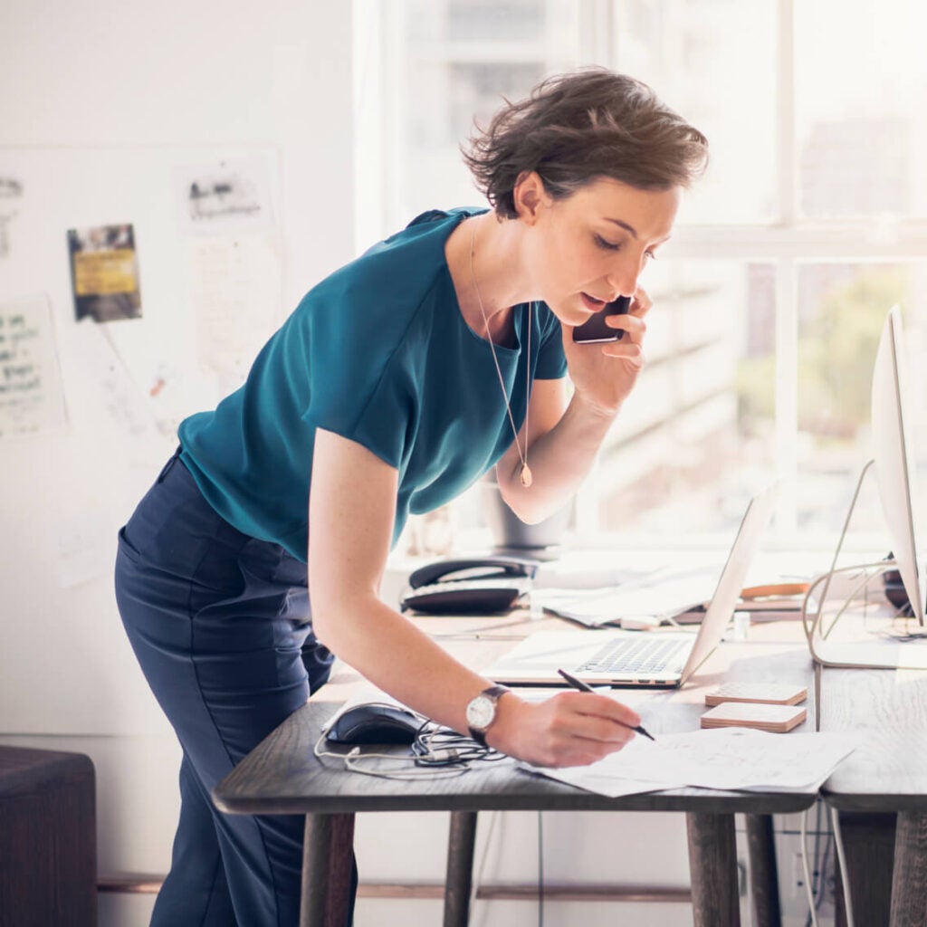 Woman on phone writing