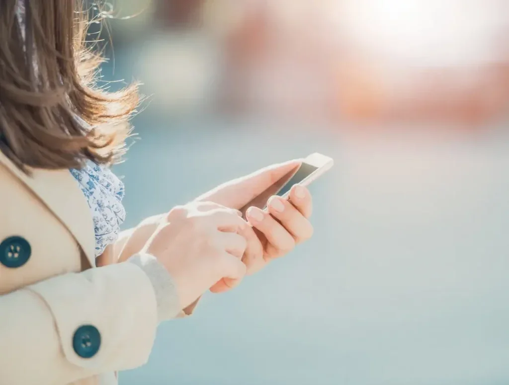 Closeup of a woman's hands holding a mobile phone.